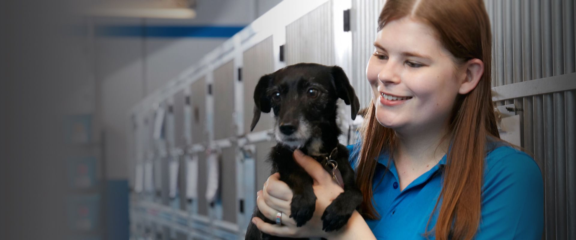 tk-9 employee holding in her arms black little dog